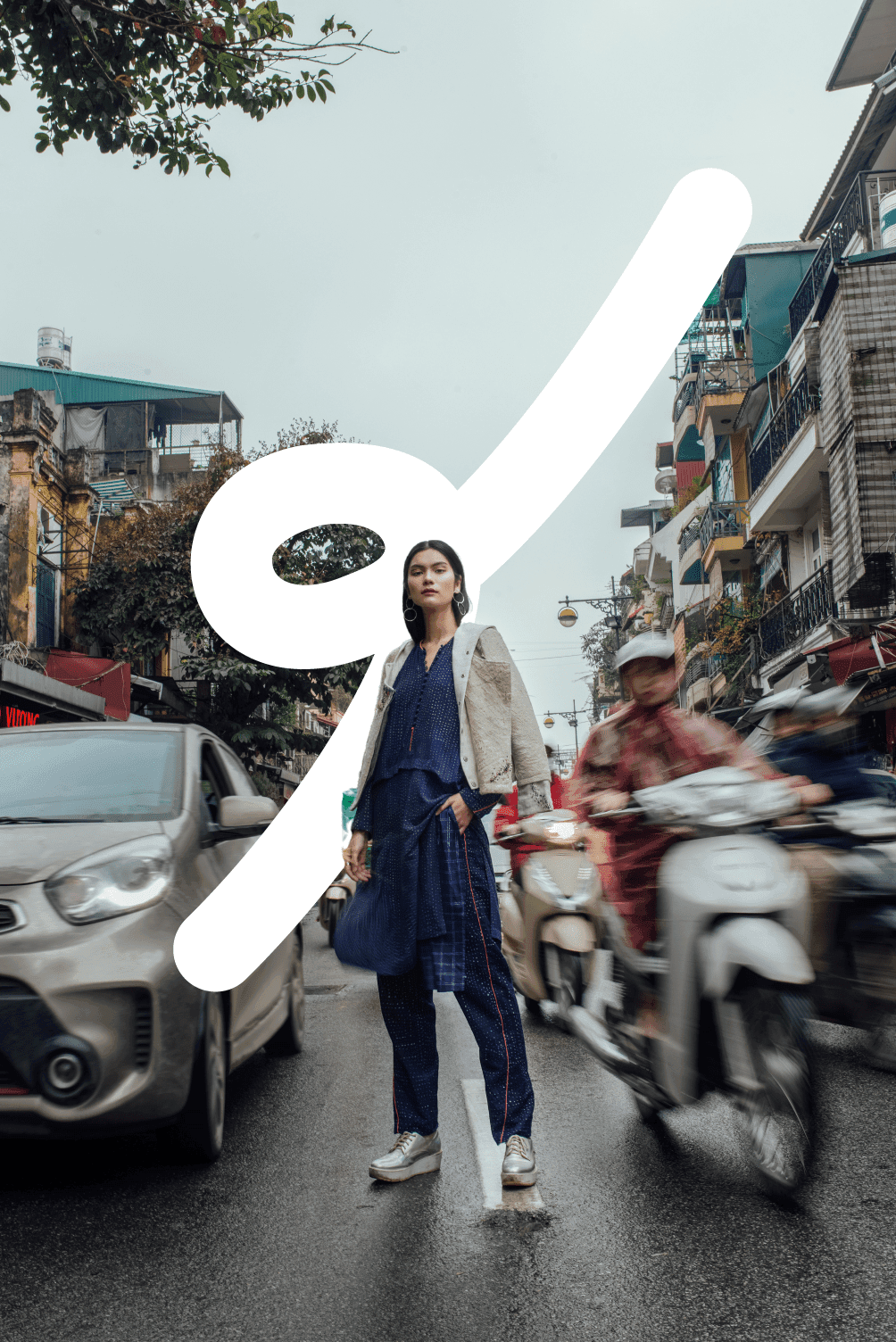 This is an image of a Vietnamese model standing in the Hanoi traffic