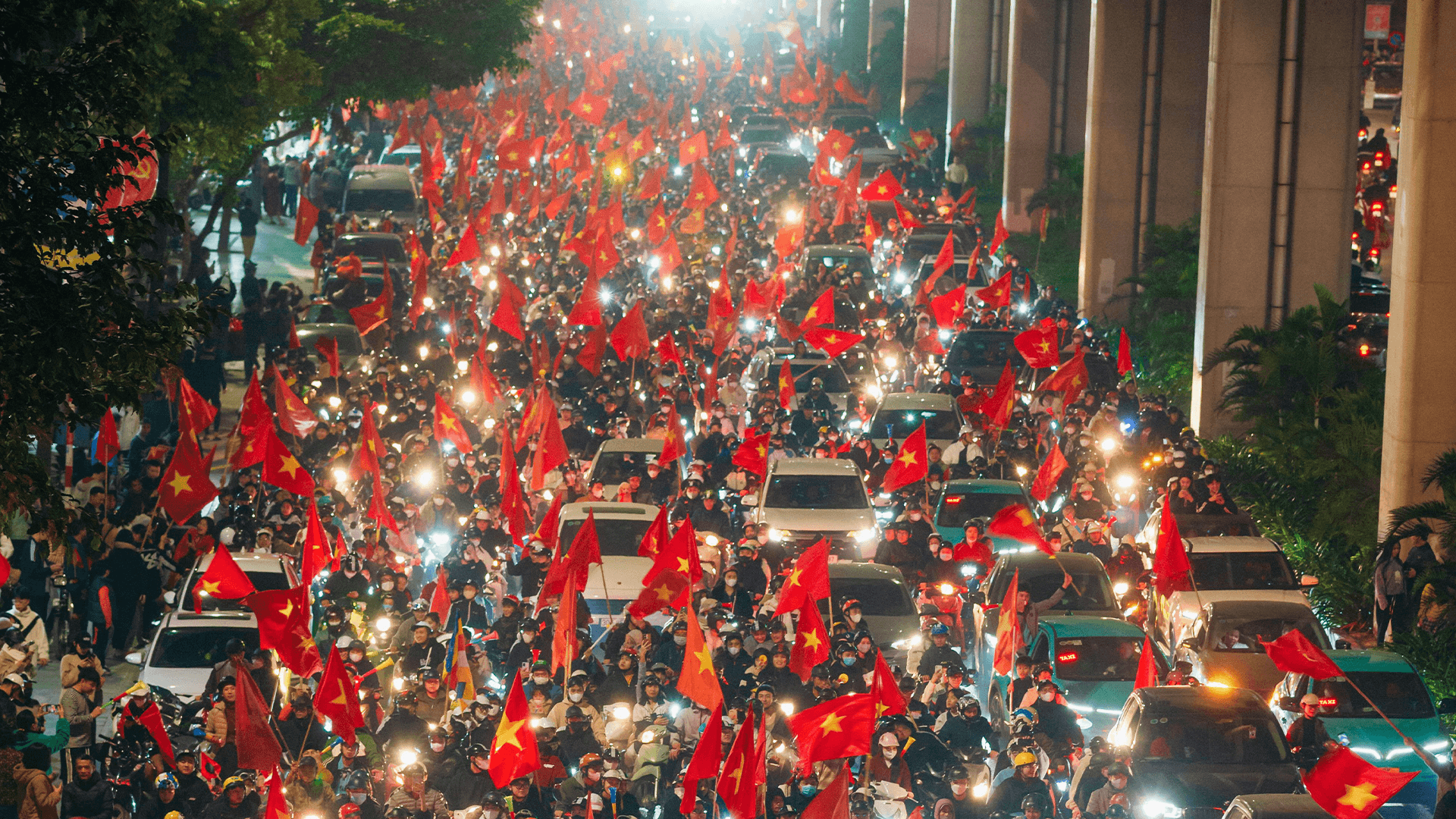 This is an image of Vietanemese football fans celebrating on the street after a national team win.